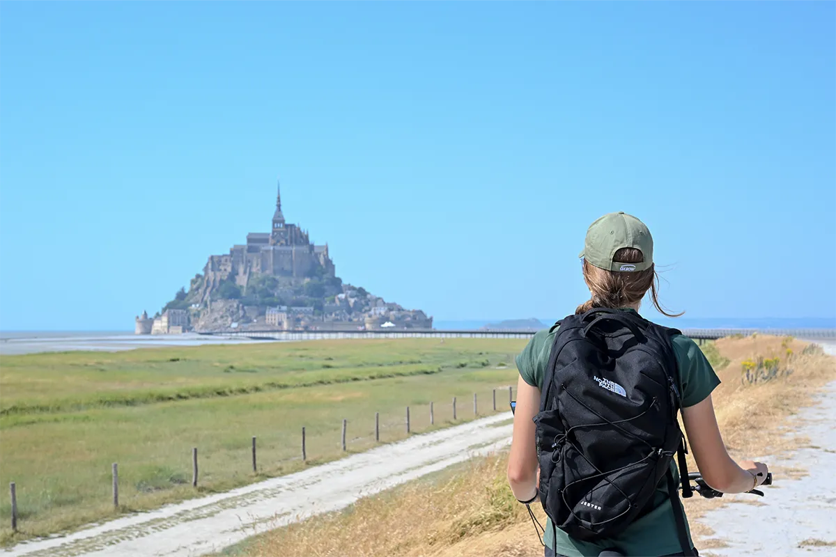 Cycliste à casquette face au Mont-Saint-Michel sur la Véloscénie