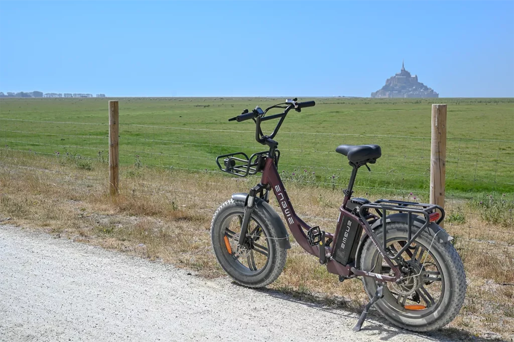 Vélo électrique fat bike garé sur un chemin blanc face à la baie du Mont-Saint-Michel