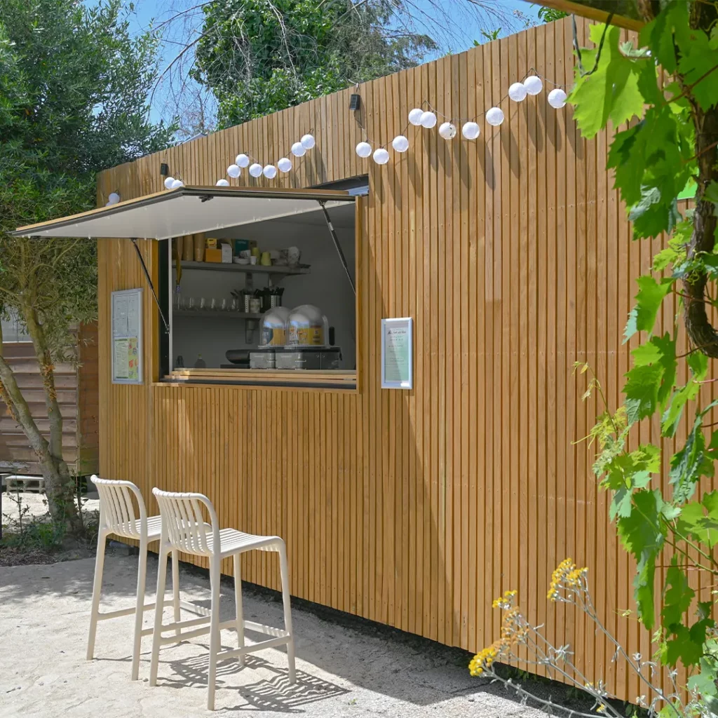 Kiosque snack en bois et guirlande lumineuse au Camping Les Chemins du Mont-Saint-Michel
