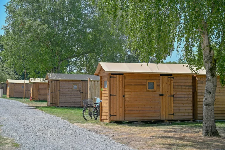 Vélo posé devant les cabanons en bois, halte idéale sur la Véloscénie